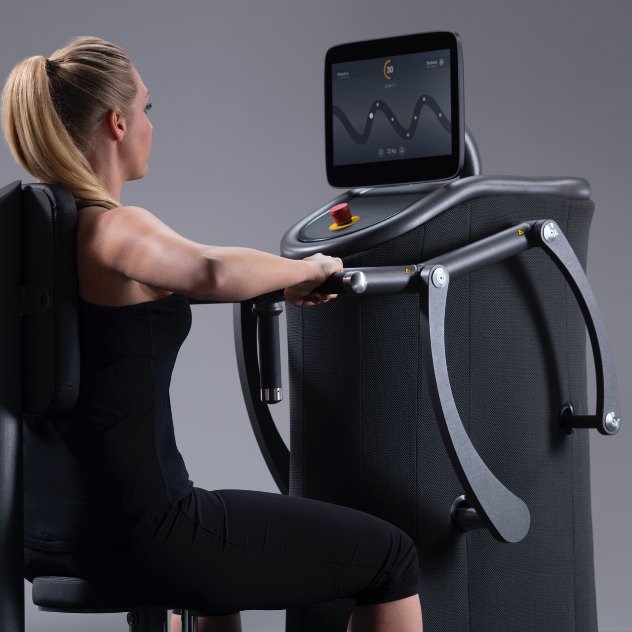 Een foto van een blonde vrouw die een apparaat van Matrix binnen Vita Fortis gebruikt. Op het apparaat worden de EGYM periodisering van de oefeningen gevisualiseerd. Je ziet de vrouw van rechtsachter.